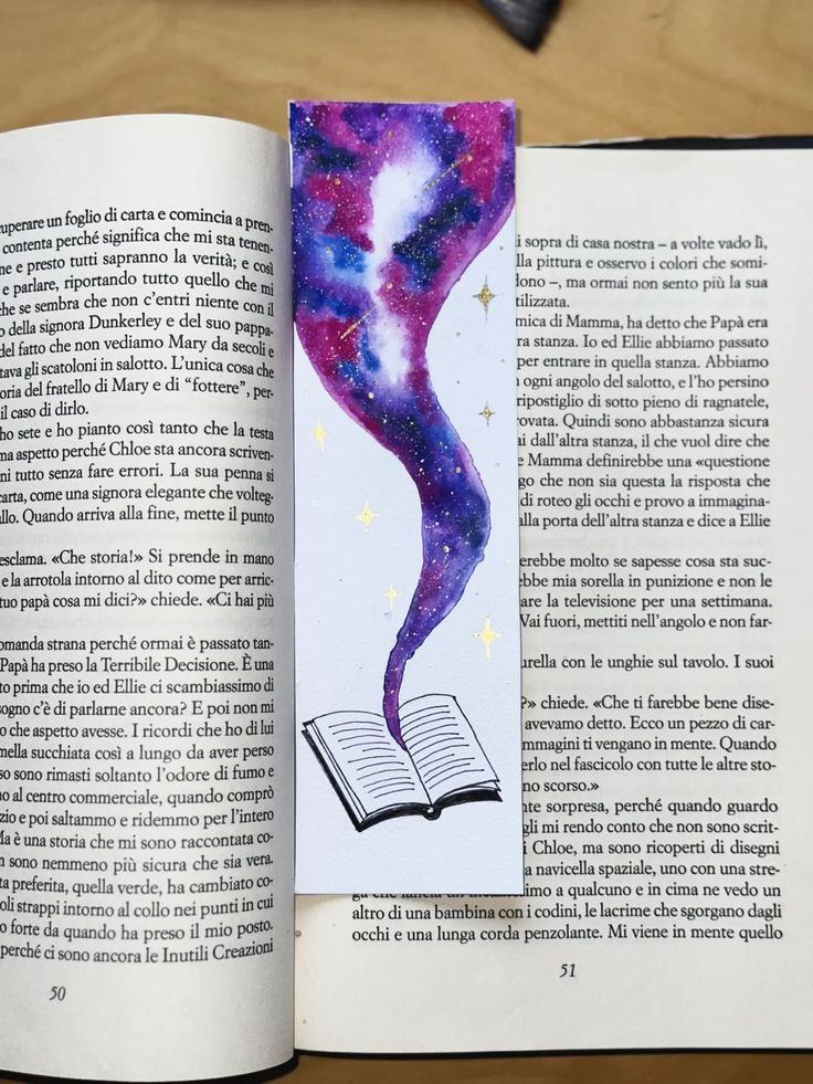 Galaxy bookmark painted in purple ink and watercolour, tucked into an open book